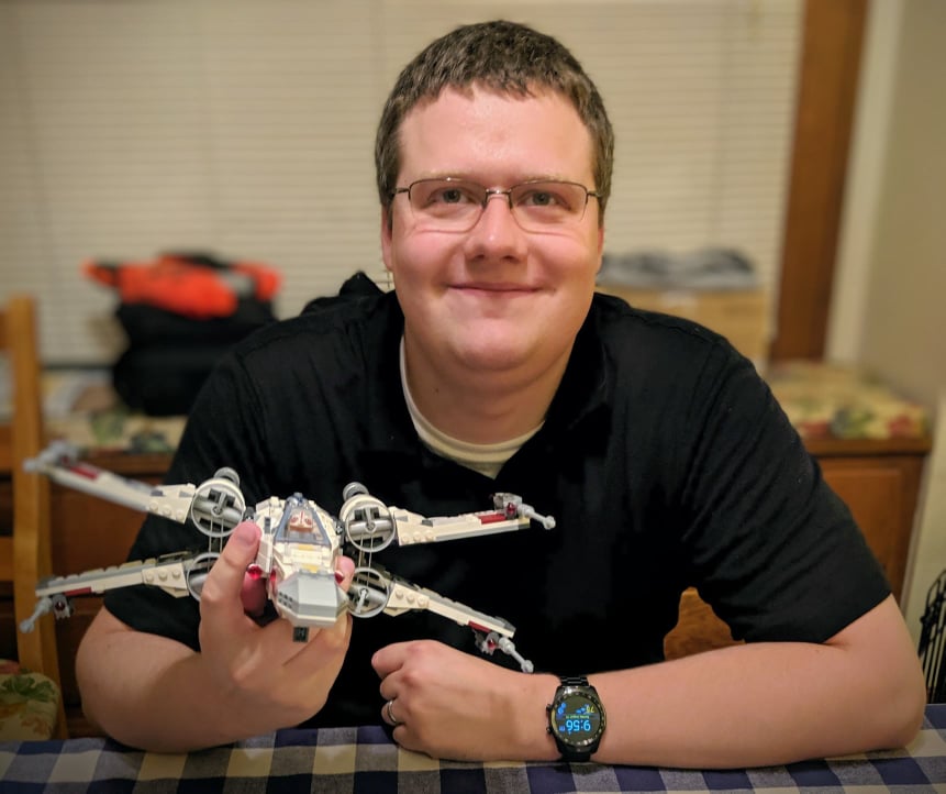 Photo of Josh Olsen holding a LEGO X-Wing,